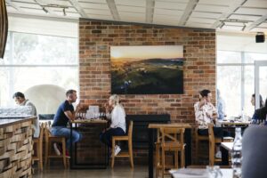 A group of people enjoying a Canberra winery tour at a table in a restaurant.