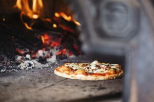 A pizza baking in a wood-fired oven at a winery in Murrumbateman.